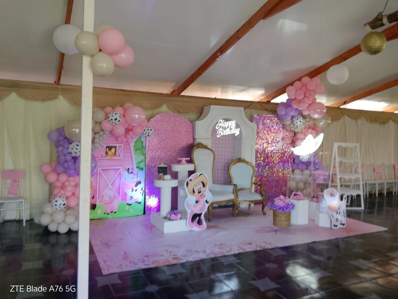 Montaje de baby shower en Manantial con globos pastel, figuras decorativas, flores y dos sillas blancas con marcos dorados.