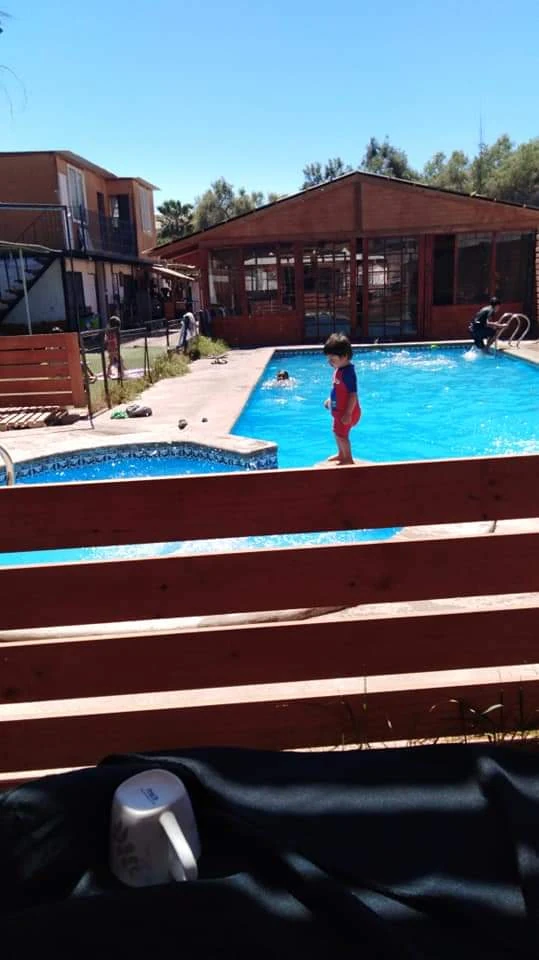 Vista de un paseo de curso en la piscina junto a las construcciones de madera de Manantial.